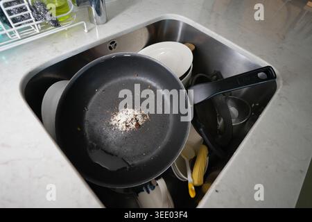 Dirty dishes and pan are in the kitchen sink Stock Photo