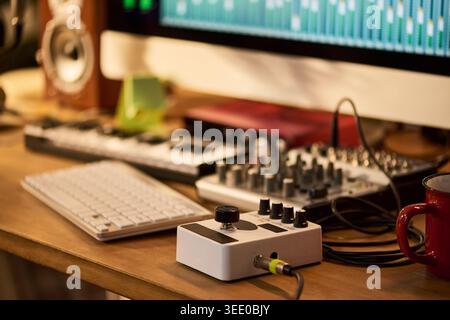 Close up of music production workstation displaying audio mixing software, keyboard, controller, interface, supporting sound design, podcast editing, recording studio marketing Stock Photo