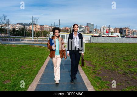 Businesswomen walking outdoors in city park discussing work Stock Photo
