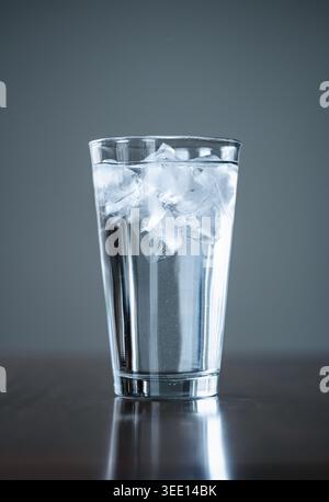 Close up of tall glass of ice water on wooden table. Stock Photo
