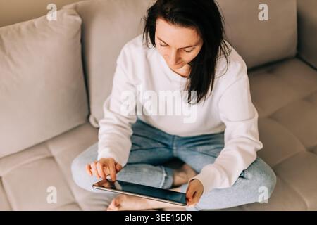 Casual female person engaging with touchscreen device Stock Photo