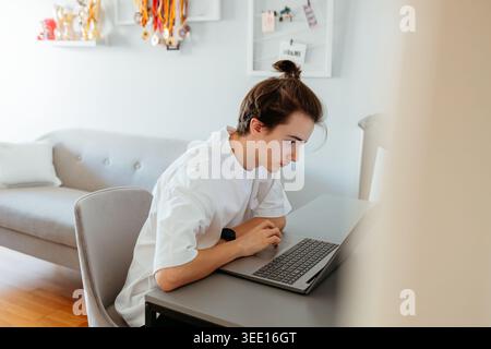 Focused person working on laptop in modern home office Stock Photo