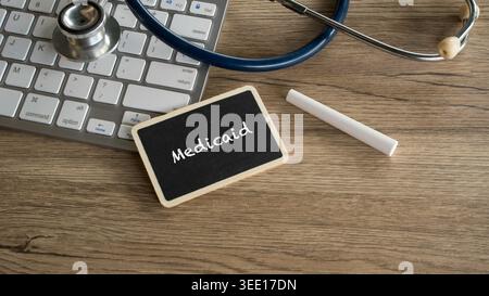 Medicaid text on blackboard sign next to computer keyboard and stethoscope for government health insurance and social security concept Stock Photo