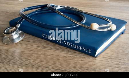 Clinical Negligence concept featuring a medical law textbook with a professional stethoscope on a rustic wooden office desk. Stock Photo