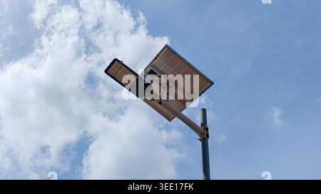 Modern solar powered LED street light against a blue sky with white clouds Stock Photo