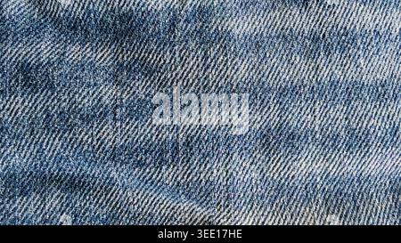 Washed out blue denim fabric texture with diagonal weave and faded pattern Stock Photo