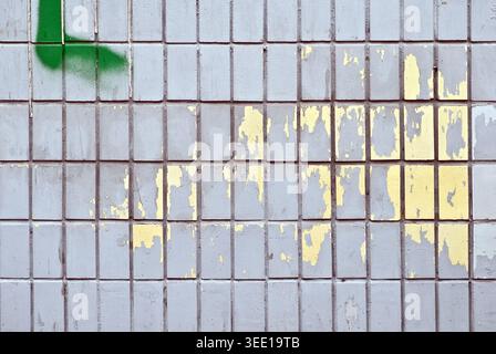 Peeling paint on a wall of tiles as a background image Stock Photo
