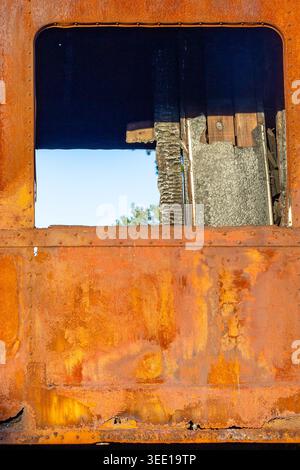 Rusty metal surface of an abandoned train car with window Stock Photo