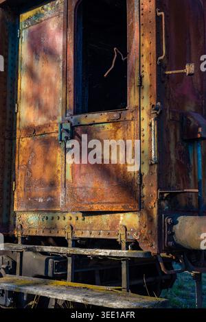 Old rusty train car door with peeling paint and rivets Stock Photo