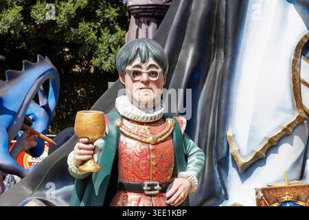 Colorful Las Fallas festival Valencia float figure of a medieval man holding a golden goblet, wearing ornate costume and glasses, with large sculptura Stock Photo
