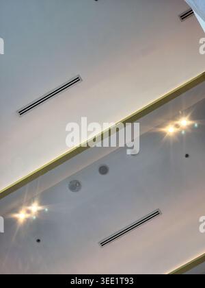 Modern minimalist ceiling design featuring recessed lighting air conditioning vent and linear architectural details creating calm and structured atmos Stock Photo