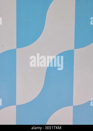 Abstract geometric pattern with alternating blue and white wavy shapes creating retro and calming optical illusion design perfect for vintage style wa Stock Photo