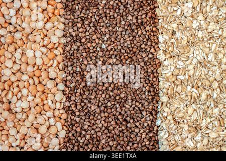 Full frame macro texture background of dry yellow split peas buckwheat groats and oatmeal flakes Stock Photo