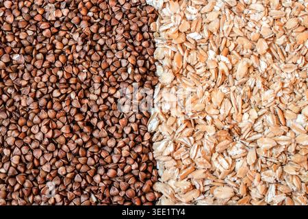 Full frame macro texture background of dry roasted buckwheat groats and rolled oat flakes split in half Stock Photo