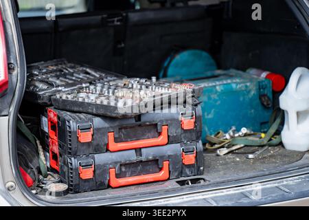 Professional tool boxes and socket wrench sets stored in the trunk of a car for mobile repair services and automotive maintenance work by technician o Stock Photo