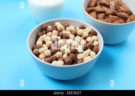 Different types of cereal in bowls on light blue background, closeup Stock Photo
