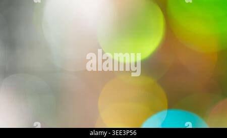 Abstract bokeh background with colorful blurred light circles in green yellow white and cyan tones Stock Photo