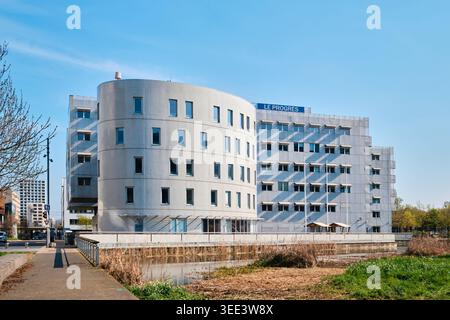 Lyon, France - March 19, 2026: The modern Le Progres building featuring a curved grey facade and rhythmic window design in the Confluence district Stock Photo