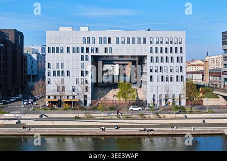 Lyon, France - March 19, 2026: Modern metallic facade with open window shutters of the MVRDV designed Le Monolithe building in Confluence Stock Photo