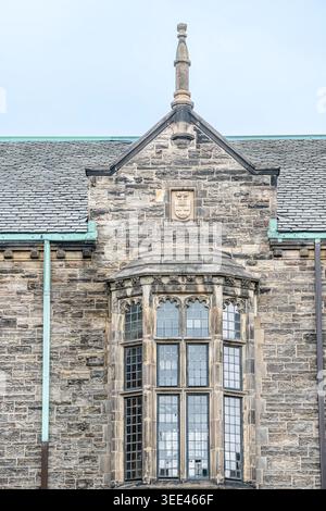 Gothic bay window and stone facade details on the historic Burwash Hall Residences building exterior. Stock Photo