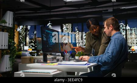 Diverse team of engineers using artificial intelligence to design a floor plan, working together with neural networks and computer aided apartment layout on architectural software. Camera A. Stock Photo
