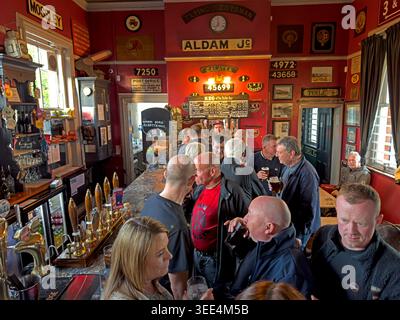 Busy CAMRA-listed Stalybridge Victorian Buffet Bar with cask ale handpumps, railway memorabilia and drinkers inside the 1885 station pub. Stock Photo