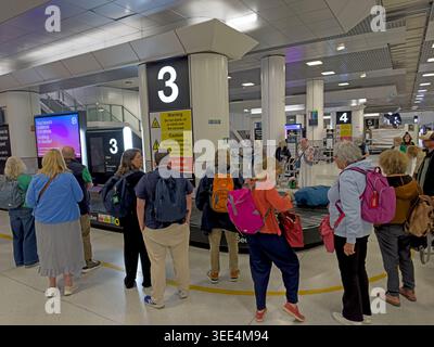 Passengers wait at baggage reclaim 3 in Manchester Airport Terminal 2 amid concerns over delayed or missing luggage. Stock Photo