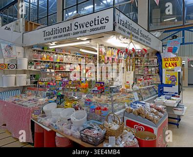 Old fashioned sweet shop stall at Wigan indoor market, packed with retro sweets, candy floss, chocolates and pick and mix treats. Stock Photo