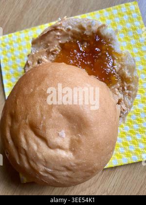 Homemade white bread roll with peanut butter and apricot jam isolated on a clear background with copy space Stock Photo
