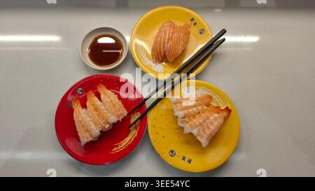 Assorted Nigiri Sushi on Colorful Plates Top View Stock Photo