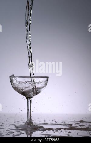 puring refreshment freshness drinking water on clean transperence glass in studio back light Stock Photo