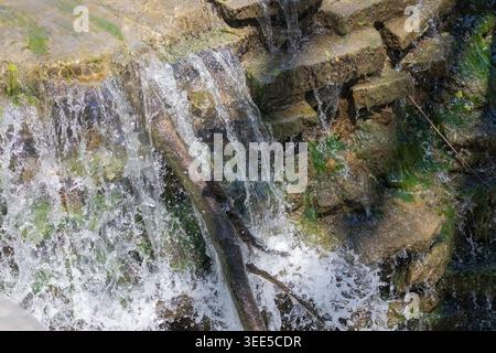 Artificial small waterfall in the park Stock Photo