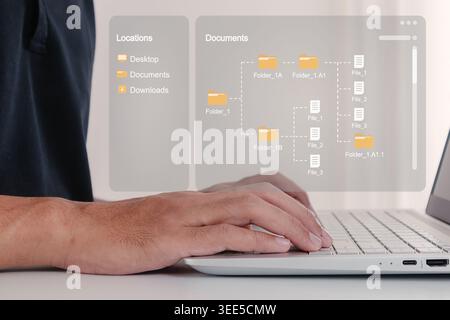 A man working on laptop with Document management system. A man searching for files or folders on his laptop. Stock Photo