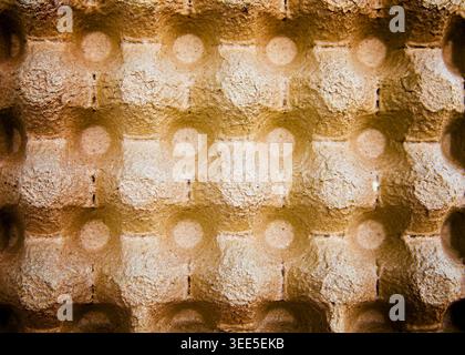 Detailed texture of an empty cardboard egg carton made from eco-friendly molded paper pulp. Abstract geometric background with copy space for design. Stock Photo