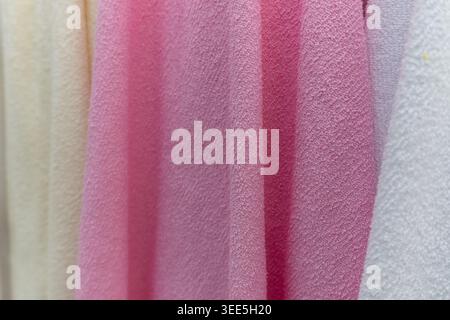 Close-up of a soft, textured fabric in shades of pink and white, draped in gentle folds. Stock Photo