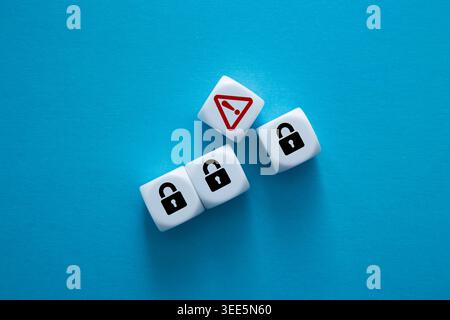 White dice showing padlocks and an exclamation mark symbol, representing a security breach Stock Photo