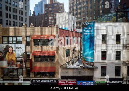 Sunlight reflected from the glass structure of the Virgin Hotel onto the surrounding buildings on Broadway, Manhattan, NYC Stock Photo