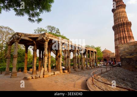 View of the ancient stone pillars and the iconic Qutub Minar tower at the UNESCO World Heritage site in Delhi India Stock Photo
