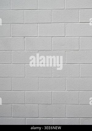 Close up of a painted white cinder block and mortar wall surface with rough block texture, smooth even mortar joints Stock Photo