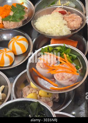 Various traditional raw dim sum dumpling meatball carrot vegetable ingredient prepared in metal dish plate before steaming cooking delicious savory mo Stock Photo