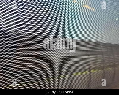Close up abstract background view through window mesh screen pattern looking out at blurred landscape feeling calm and contemplative Stock Photo