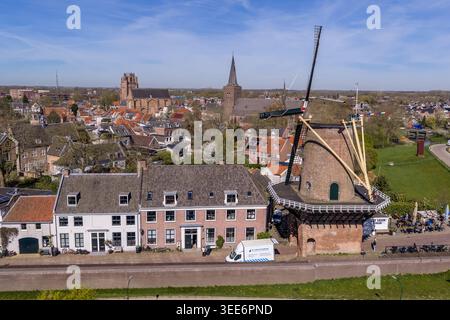 Aerial drone view juxtaposing two of the most iconic elements of Wijk bij Duurstede in Utrecht province, Netherlands: in the foreground, the Molen Rij Stock Photo