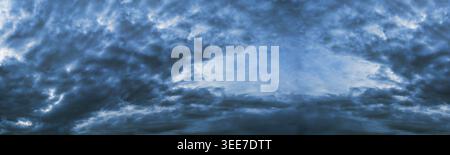 Dark cloudy sky with break in the clouds. Dark blue gloomy heaven cloudscape. Nature dramatic skyscape wide panoramic background Stock Photo