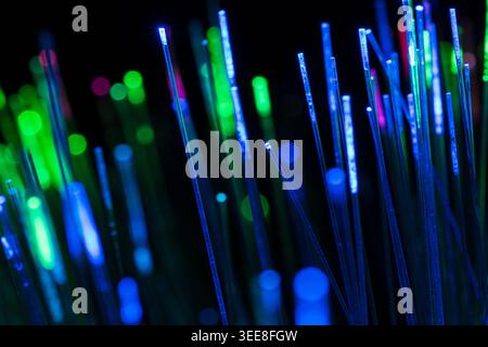 Creative abstract close-up of blue and green glowing fiber optic lights with shallow focus. Represents digital networking, communication technology, i Stock Photo