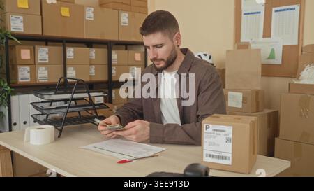 Man counting dollar bills and handling parcels at a shipping desk inside a building; small business diligence. Stock Photo