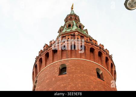 Red Brick Tower With Green Spire, Lowangle Shot Capturing Textured Masonry, Rounded Turrets, Decorative Cornices, Pale Sky Background, Warm Tones, Stock Photo