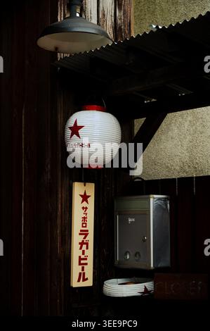 Japanese paper lantern with Sapporo Beer branding hanging on wooden exterior in Kamakura, Japan Stock Photo