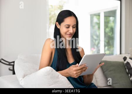 Attractive woman using digital tablet at home Stock Photo