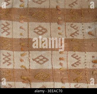 Handwoven wool rug showcasing detailed geometric patterns, rich textures, and warm brown and beige stripes, reflecting authentic textile craftsmanship Stock Photo