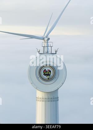 Netherlands - 26 November 2025: Aerial view of two technicians sitting inside a wind turbine hub above a thick layer of clouds. Stock Photo